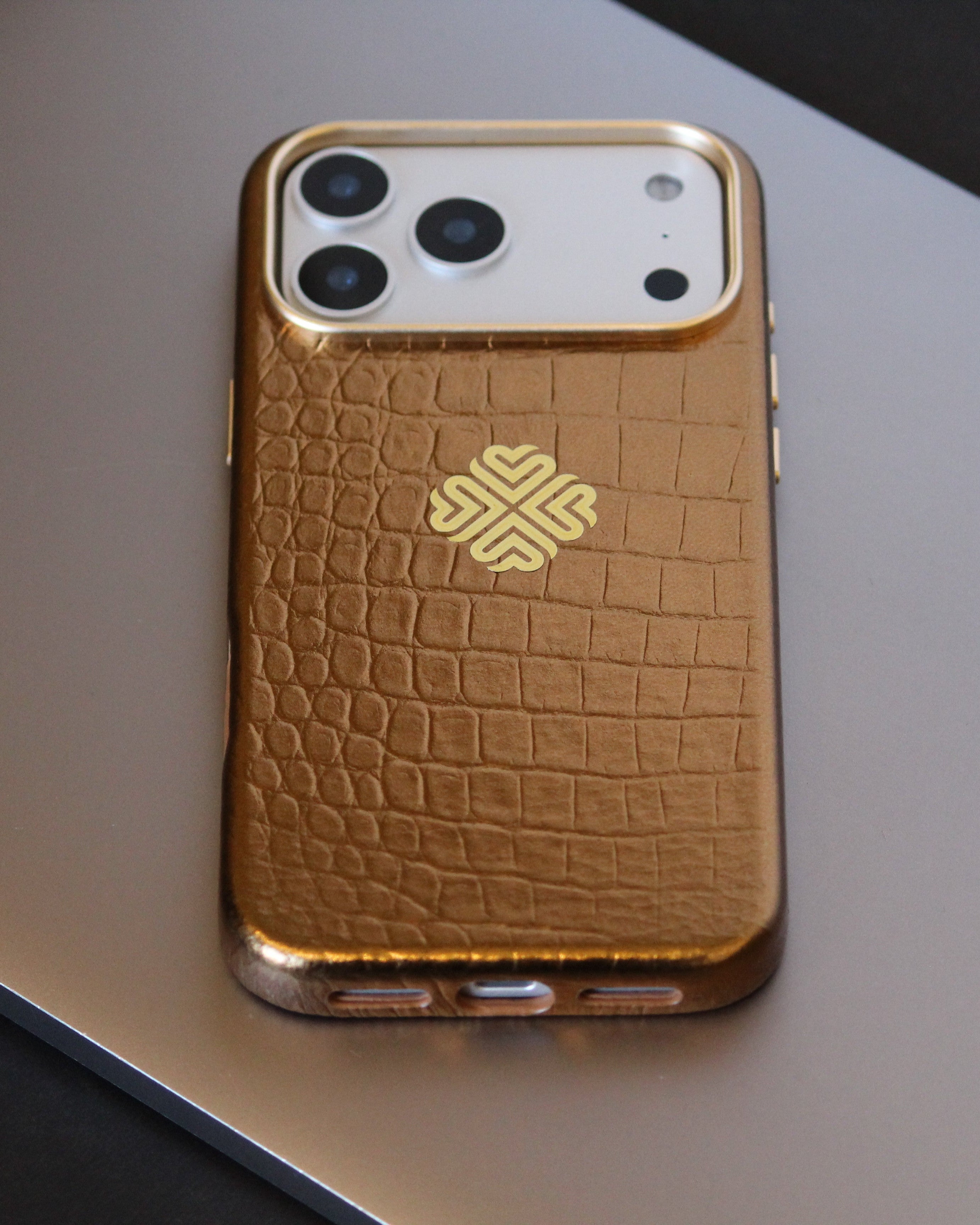 orange crocodile-patterned phone case on a reflective surface